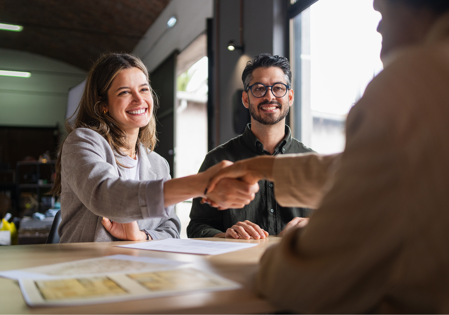 Happy couple shaking hands with advisor